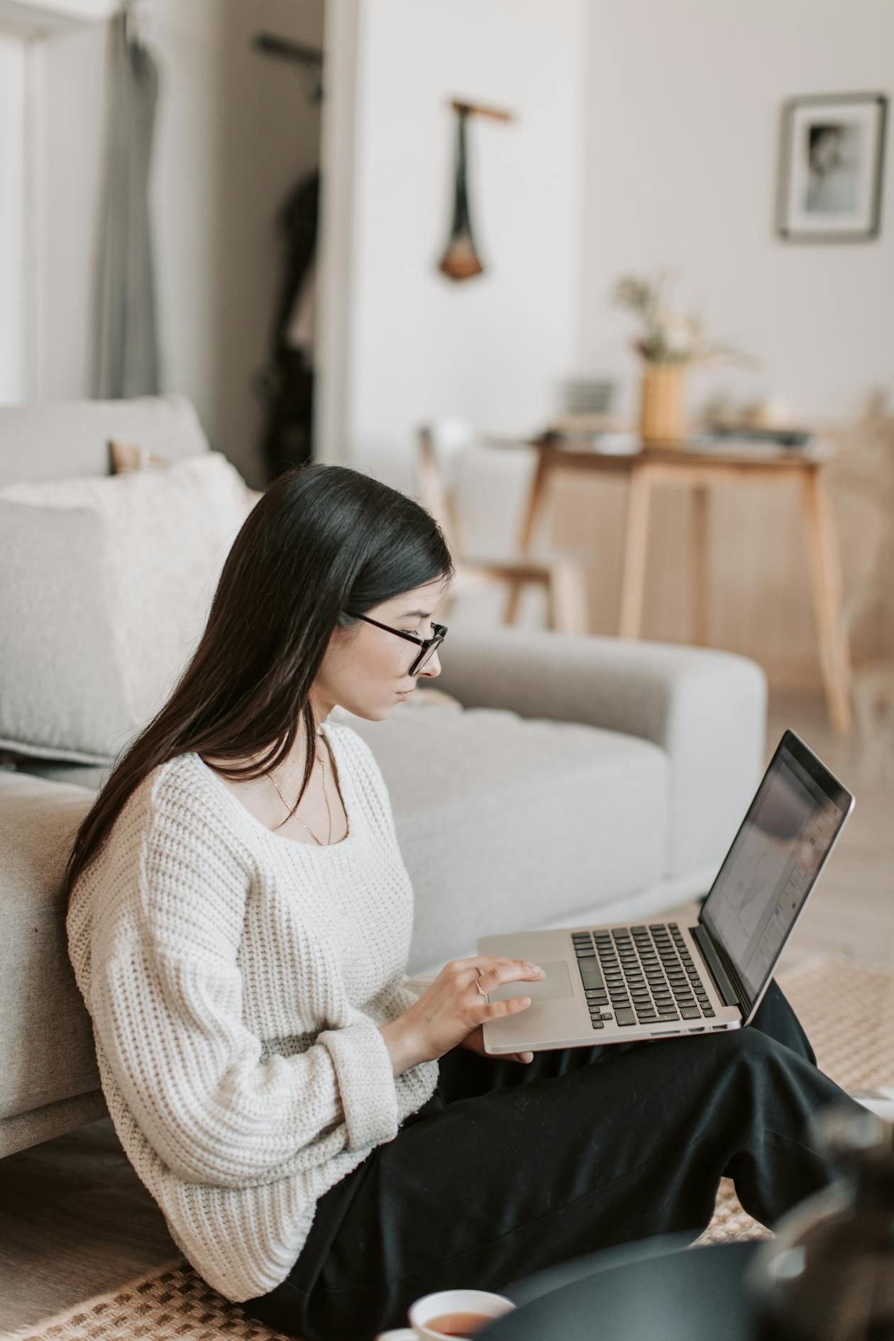 Kvinna läser på laptop hemma — juridisk guide till folkbokföring och posthantering